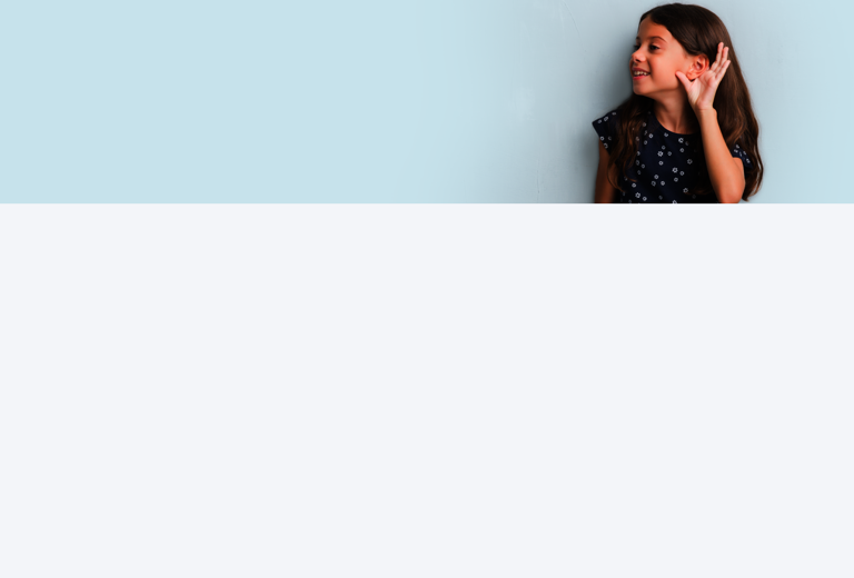 Ein Mädchen hält die Hand ans Ohr, um besser zu hören